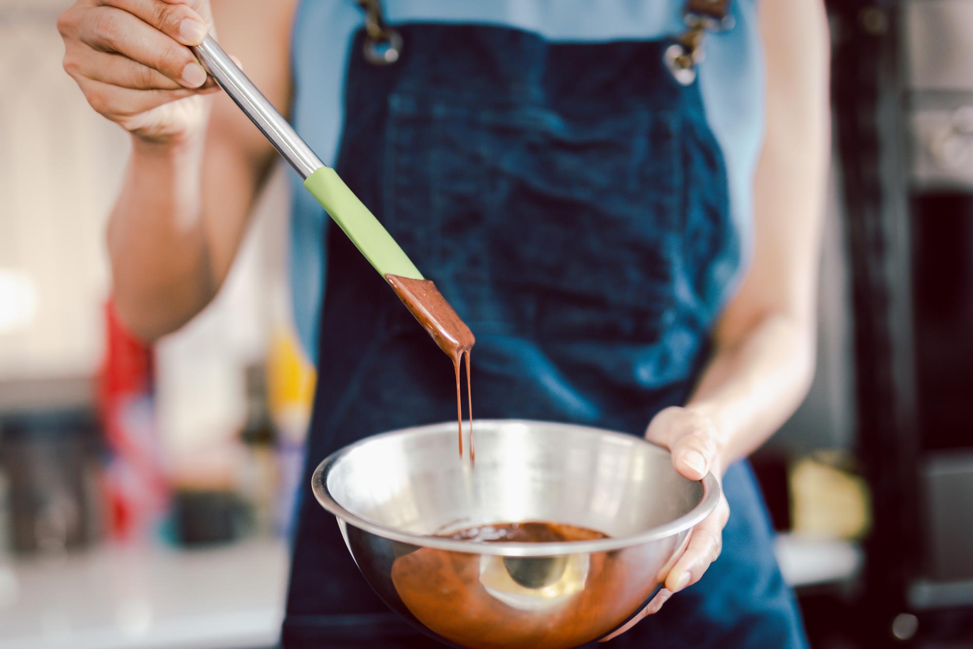 artisan chef stirring sauce in copper pan